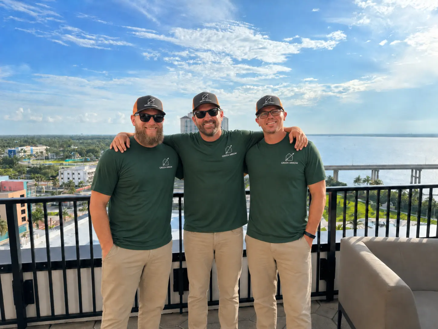 Green Arrow Property Services owners wearing branded shirts and hats
